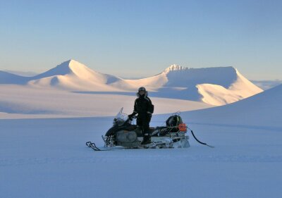 Researcher on snowmobile in snowcovered landscape at Svalbard