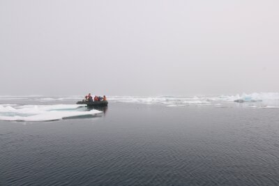 Dingy boat with researchers and partly ice covered sea in Svalbard