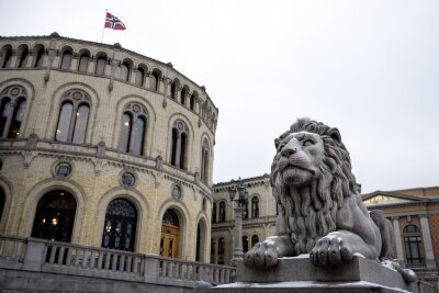 Stortinget med flagget heist og en løvestatue. Foto: Jonas Bendiksen