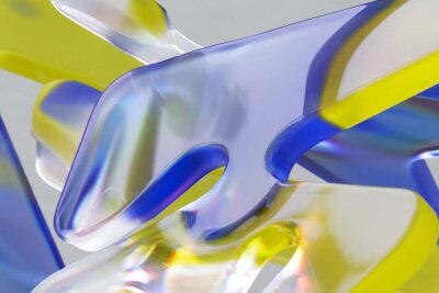 Abstrakte former i glass som er gul, blå og grå