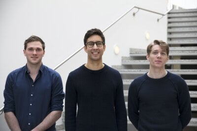Tre unge menn foran en trapp