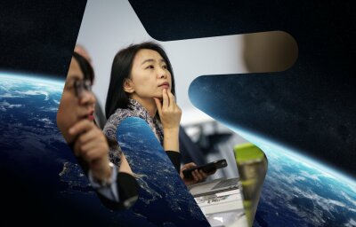 To asiatiske forskere med satelittbilde av jordkloden i bakgrunnen
