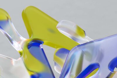 Abstrakte former i glass som er gul, blå og grå