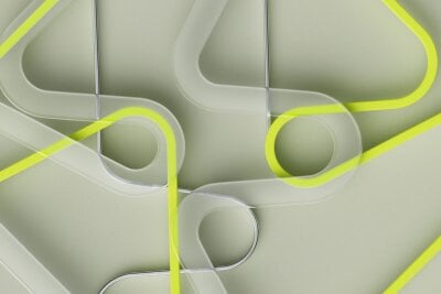 Abstrakte former i glass, sølv og neon gul, som ligner på tråder.
